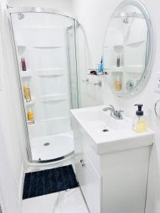a white bathroom with a shower and a sink at Master Bedroom with Full Washroom, free wi-fi, free Parking near Fairview Park Mall ROOM 3 in Kitchener