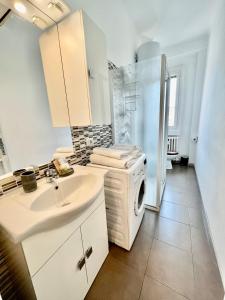 ein Badezimmer mit einem Waschbecken und einer Waschmaschine in der Unterkunft Cozy Apartment 3 km away from Duomo in Mailand