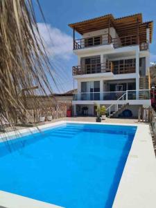 una casa con piscina frente a una casa en Casa Cárpena Playa Acapulco Zorritos en Zorritos