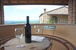 una botella de vino sentada en una mesa con dos copas de vino en AGRITURISMO VICOLABATE, en San Casciano in Val di Pesa