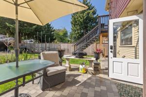 a patio with a table and an umbrella at 2 luxury Queen beds w marble bath 5 min walk to the drive Free parking in Vancouver
