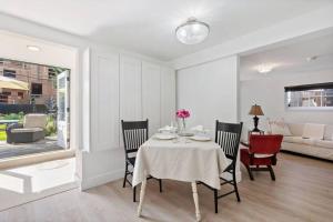 a dining room with a table and chairs at Carrington Chateau Courtyard suite w 2 Queen Beds & marble bathroom in Vancouver