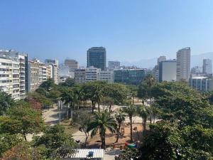 a city with a park with palm trees and buildings at Três suítes há poucos passos da praia in Rio de Janeiro