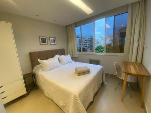 a bedroom with a bed and a large window at Três suítes há poucos passos da praia in Rio de Janeiro