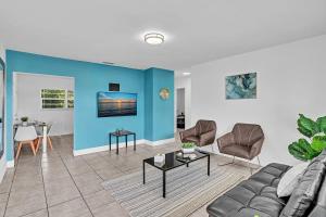 sala de estar con sofá y pared azul en Modern 2br Oasis Mins To Beach & Casino Db2, en Dania Beach