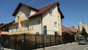 a large house with a fence in front of it at Garsoniera Strada Bucegi in Sibiu