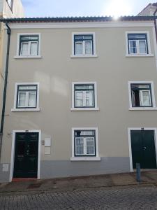 um edifício branco com portas e janelas verdes em Casa Camões em Bragança