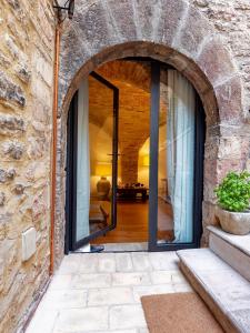 une porte voûtée menant à une maison avec un mur en pierre dans l'établissement Saint Francis Studio Apartment, à Assise