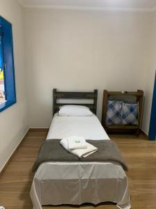 een slaapkamer met een bed met twee handdoeken erop bij Pousada Fazendinha Alto da Serra in Serra Negra