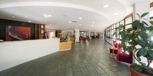 a lobby of a building with a plant in the foreground at Laias Caldaria hotel y Balneario in Laias