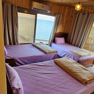 3 Betten in einem Zimmer mit Meerblick in der Unterkunft Mermaid camp in Nuweiba