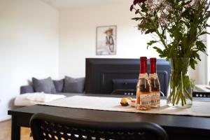 dos botellas de vino en una mesa con un jarrón de flores en *TOP Apartment* beliebte Lage* in Düsseldorf, en Düsseldorf