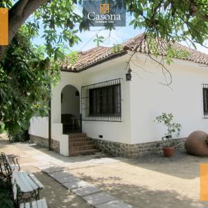 ein weißes Haus mit einer Bank davor in der Unterkunft Casona los Naranjos, Olmué in Olmué
