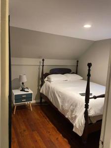 1 dormitorio con 1 cama y 1 mesa con lámpara en Comfortable home away from home, en East Hartford