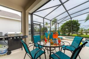 a patio with a table and chairs and a pool at The Dream Vacation Home! in Orlando