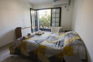 um quarto com uma cama grande e uma janela em Mono Simply en Barrio Norte em San Miguel de Tucumán