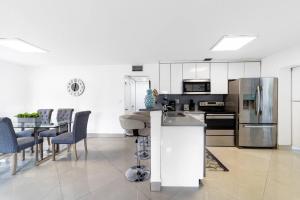 a kitchen and dining room with a stainless steel refrigerator at Private Heated Pool Villa In Ftl Near Beach in Fort Lauderdale