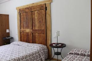 ボルノにあるB&B Navertinoのベッド1台と木製のドアが備わる客室です。