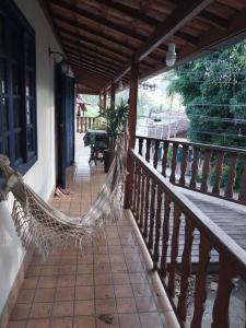 um alpendre com uma rede de descanso numa casa em Casa 2 Cantina Florêncio São Pedro da Serra em Nova Friburgo