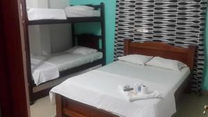 a bedroom with two bunk beds and a mirror at Hotel Los Estoraques in Aguachica