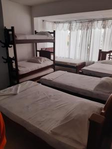 a room with four bunk beds and a window at Hotel Los Estoraques in Aguachica