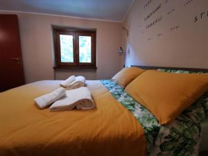 a yellow bed with towels on top of it at LA CASA DEL GRILLO - Valle del Menotre - Rasiglia in Orsano