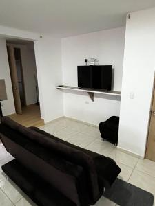 una sala de estar con un sofá negro en una habitación en Apartamento pitalito, en Pitalito
