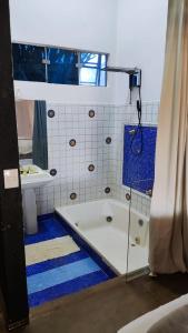 a bathroom with a bath tub and a sink at Charmosa Casa no Lago in Ribeirão Preto