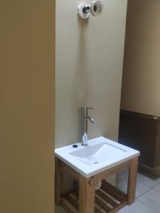 Baño con lavabo blanco y papel higiénico en Departamentos Centro en Villa Dolores