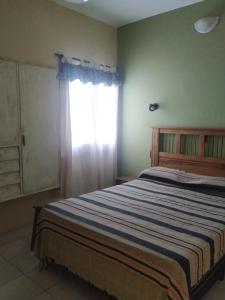 1 dormitorio con 1 cama grande y ventana en Departamentos Centro en Villa Dolores