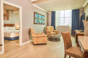 een hotelkamer met een bed en een tafel en stoelen bij Waymore Hotel Spa & Casino in Panama-Stad