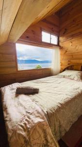 sypialnia z dużym łóżkiem i oknem w obiekcie Cabaña en La Laguna de la Cocha w mieście Pasto