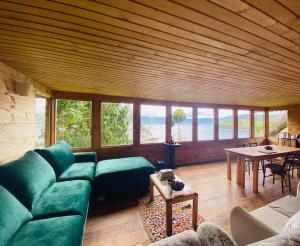 帕斯托Cabaña en La Laguna de la Cocha的客厅里有一张绿色的沙发和一张桌子