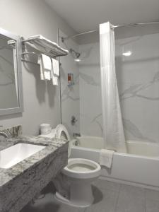 La salle de bains est pourvue de toilettes, d'une baignoire et d'un lavabo. dans l'établissement Relax Inn Mcgehee, à McGehee
