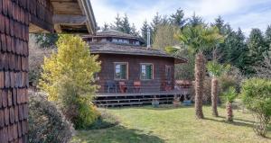 a small house with a balcony on top of a yard at Zapato Amarillo Bed & Breakfast in Puerto Octay