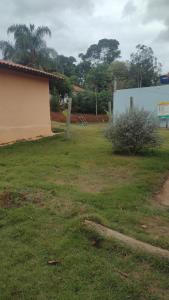 een tuin met een gebouw en een struik bij SITIO CAMINHO DAS PEDRAS - Suítes e Chalés in São Thomé das Letras