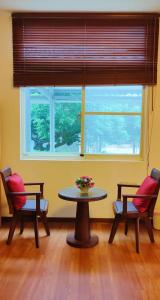 Shan-lin的住宿－登雲villa，客房设有桌子、两把椅子和窗户。