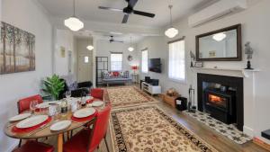 a living room with a table and a fireplace at Creekview Cottage - 70 Lock Street in Stanthorpe