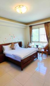 Shan-lin的住宿－登雲villa，一间卧室设有一张大床和一个窗户。