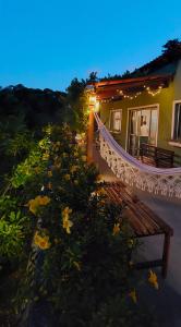 a house with a hammock and flowers in front of it at Casa de Mar Sagi in Baía Formosa