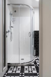 een glazen douche in een badkamer met een geruite vloer bij Lavender Box in Dunedin