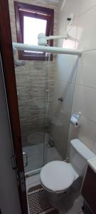 uma casa de banho com um WC e uma cabina de duche em vidro. em Village Shalom Casa 6 - Porto de Sauipe em Porto de Sauípe