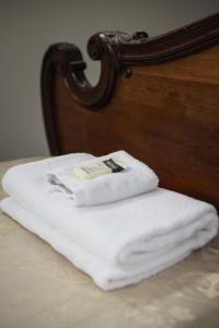 uma pilha de toalhas brancas sentadas numa cama em Lavender Box em Dunedin