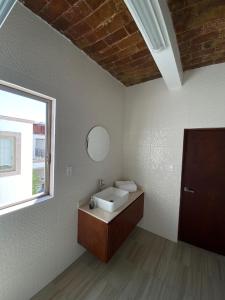 La salle de bains est pourvue d'un lavabo et d'une fenêtre. dans l'établissement Los Arcos Hottel Boutique, à Morelia