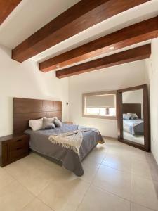 - une chambre avec un grand lit et un miroir dans l'établissement Los Arcos Hottel Boutique, à Morelia