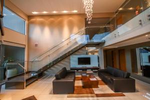 a living room with a tv and a staircase at Gales Park Hotel in Dourados +30 photos