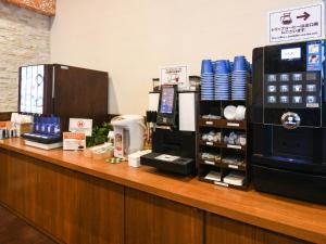 a store counter with a cash register and a coffee shop at Vessel Hotel Fukuoka Kaizuka in Fukuoka