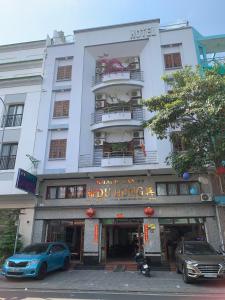 um edifício com um carro azul estacionado em frente dele em Du Hung 2 Hotel em Hà Tiên