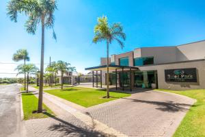 a building with palm trees in front of it at Gales Park Hotel in Dourados