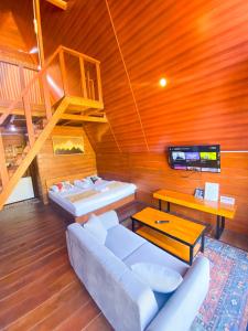 Godieng Cabin في Diyeng: غرفة معيشة مع أريكة وتلفزيون في منزل
